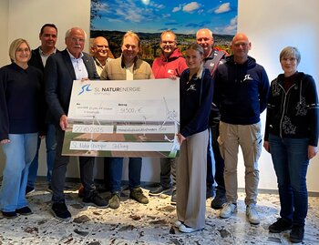 Große Freude bei 21 Vereinen aus Neuenrade und Bürgermeister Antonius Wiesemann (3.v.l.): Vivien Thomae (4.v.r.) und Robert Daniels (2.v.r.) von der SL NaturEnergie GmbH überbrachten den symbolischen Spendenscheck.